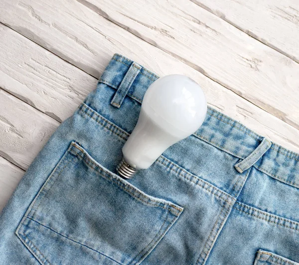 Top view light bulb in pants pocket. Electrical concept. Energy saving lamp for lamp.
