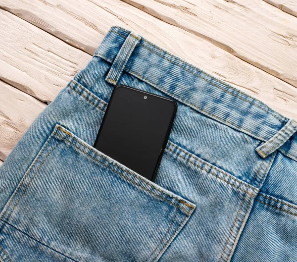 Top view smartphone in denim pants pocket. Phone in blue jeans pocket.