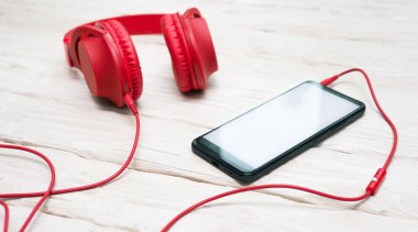 Background Overhead red headphones with smartphone. Desktop. Online education. Home Office. copy space