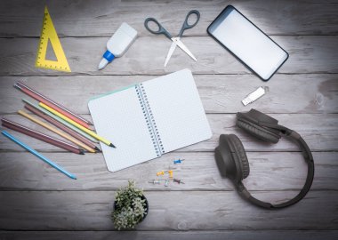 Top view overhead headphones musical overhead with blocktone for text. Home office with pencils and sticker. Scissors. Space copy. Office. Desktop. Online education. Workplace background.