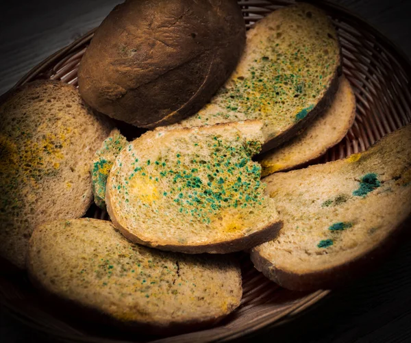 Bread with mold in a straw basket, bread with fungus, food poisoning, microbes. Flowered bread.