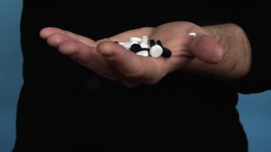 Medical pills, activated charcoal in a man's hand, pouring pills into his hand. Pour the capsules into your hand. In slow motion. Medicine concept. Treatment with tablets.