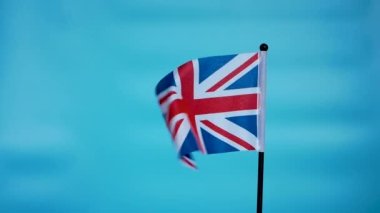  İngiltere bayrağı rüzgarda, Britanya bayrağı mavi arka planda. Uzayı kopyala Büyük Britanya Birleşik Krallığı bayrağı rüzgarda dalgalanır.
