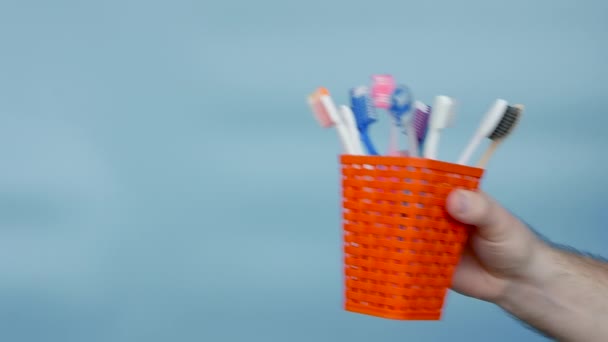 Variety Toothbrushes Man Hand Blue Background Set Toothbrushes Orange Case — Vídeo de Stock