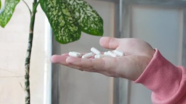 Pouring medical pills with capsules on the palm of a person's hand. A man's hand holds a lot of medicinal tablets in his hand. The concept of treatment with pharmaceutical drugs