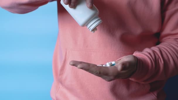 一个男人从罐子里把一个白色的药丸倒入他的手心里 健康的概念和用药丸对抗疾病的治疗 这个人正在服用抗生素或抗抑郁药 — 图库视频影像