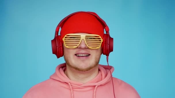 Νεαρός Δημιουργικός Άντρας Μουσικά Ακουστικά Όμορφο Χαμόγελο Μπλε Φόντο Ένας — Αρχείο Βίντεο