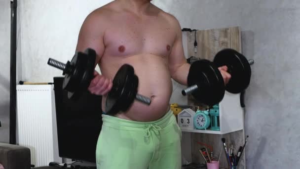 太っている太った男が家の中に彼の筋肉をポンプします ライフスタイル 腹の大きい太った男が足を見せる 肥満の人々 減量の概念 — ストック動画
