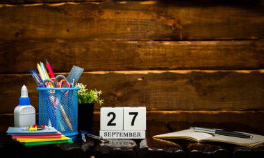 Eylül takviminde 27 numara var. Ofis arka planı kalem ve cetvel fotokopi alanı. Kahverengi ahşap zemin üzerinde güzel bir arkaplan planlayıcı takvimi, metin için boşluk.