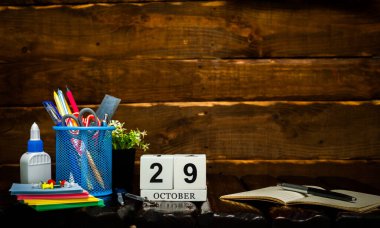 Ekim takviminde 29 numara var. Ofis arka planı kalem ve cetvel fotokopi alanı. Kahverengi ahşap zemin üzerinde güzel bir arkaplan planlayıcı takvimi, metin için boşluk.