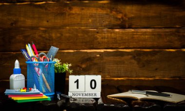 10 numarayla Kasım takvimi. Ofis arka planı kalem ve cetvel fotokopi alanı. Kahverengi ahşap zemin üzerinde güzel bir arkaplan planlayıcı takvimi, metin için boşluk.