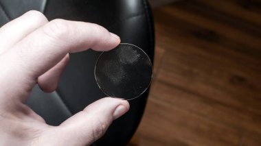 Bir adamın elinde çizilmiş bir saat camı. Yapay kristal ya da saatler için silikat cam. Kırık saat camı. Çizilmiş görüntüyü göster.