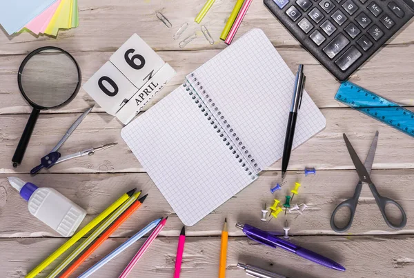 stock image April calendar with number  6. Copy of space note. Top view of blank notepad. Space for text in a checkered sheet, stationery background with accessories.