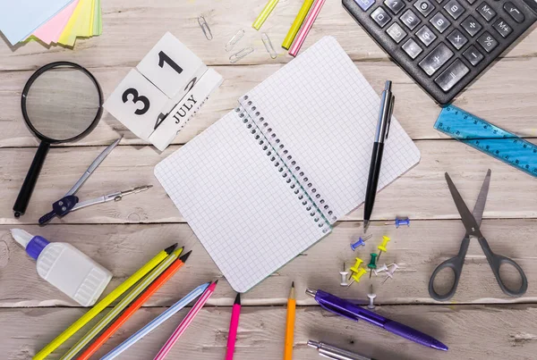 stock image July calendar with number  31. Copy of space note. Top view of blank notepad. Space for text in a checkered sheet, stationery background with accessories.