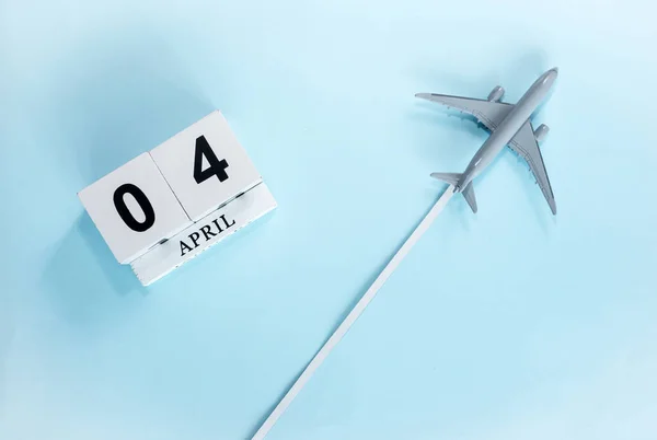 四月历4号带着飞行客机的日历的顶部视图 时间安排 旅行概念 复制空间 — 图库照片