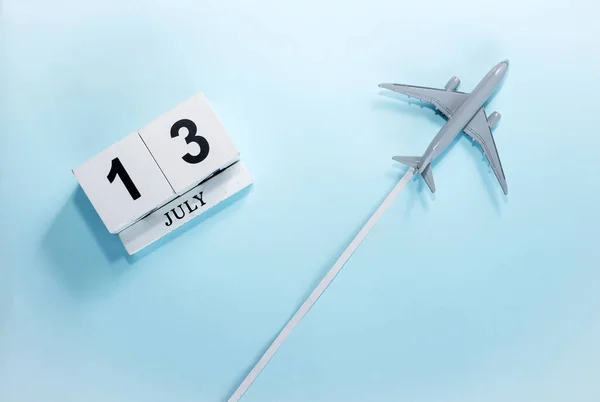 7月13号的日历带着飞行客机的日历的顶部视图 时间安排 旅行概念 复制空间 — 图库照片