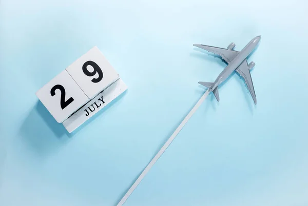 七月二十九号的日历带着飞行客机的日历的顶部视图 时间安排 旅行概念 复制空间 — 图库照片