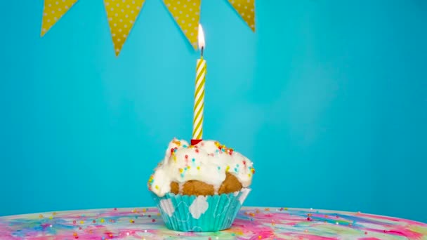 节庆奶油蛋糕在带有花环装饰的纺纱机上 孩子生日快乐 生日布丁杯蛋糕 点着蜡烛 还有蓝色背景的装饰品 复制空间 — 图库视频影像