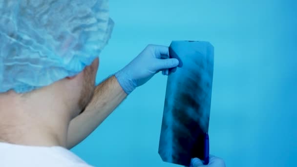 의사는 엑스레이에서 사람의 갈비뼈를 병원에서 근무하는 의료진 갈비뼈의 엑스레이를 분석하는 — 비디오