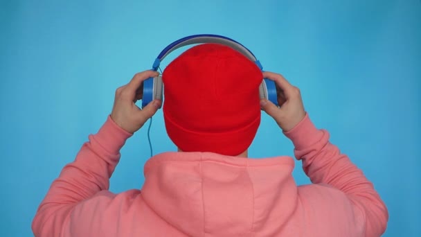Повільний Рух Одягається Музичні Навушники Синьому Фоні Молодий Стильний Чоловік — стокове відео