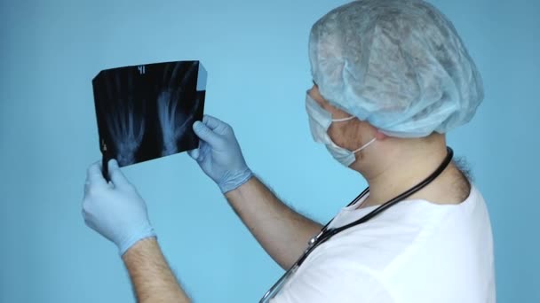 Traumatólogo Con Uniforme Médico Hospital Analiza Una Radiografía Una Mano — Vídeo de stock