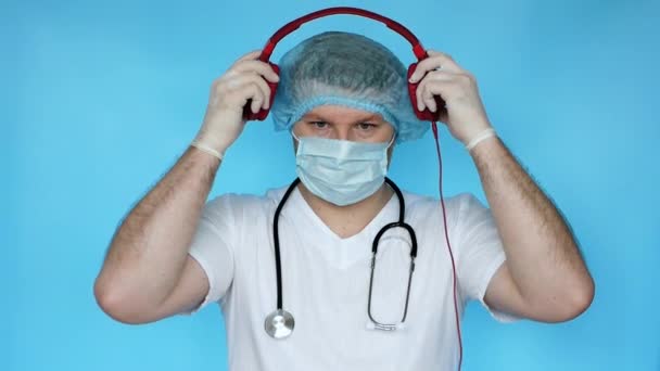 Erkek Bir Doktor Kafasına Müzik Kulaklığı Takıyor Tıp Üniformalı Bir — Stok video