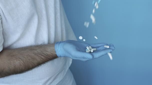医生手里拿着药丸胶囊 慢动作 把药丸从药瓶中倒入手部 携带医疗手套及治疗疾病的药丸 — 图库视频影像