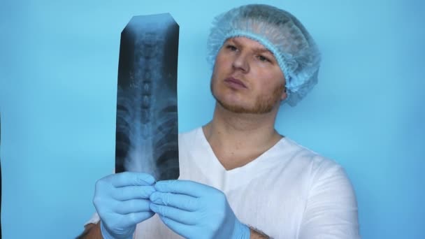 医者は病院のX線で人間の背骨の問題を診断します 病院の医療従事者は脊髄症のX線を分析します 制服を着た医者 — ストック動画