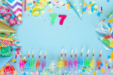 Üst görüş kartı 77 numarayla mutlu yıllar. Uzayı kopyala Kartpostallı tatil yıldönümü. Mutlu yıllar erkek metni için çok renkli arkaplan, pastel renklerde güzel süslemeleri olan bir rakam.