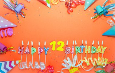 Üst görünüm doğum günü arkaplanı 12 numara. Renkli bir arkaplanı olan güzel bir bayram kartpostalı. Bir şarkıyla yıldönümü kutlamaları. Mumların doğum gününden sözler.
