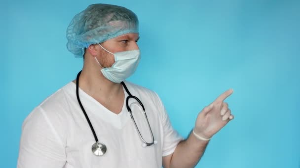医者は来るように手を指差している 医者は患者に電話する ボディランゲージ 人差し指で指差す手のジェスチャー 先生とのStethoopとマスクと医療制服 — ストック動画