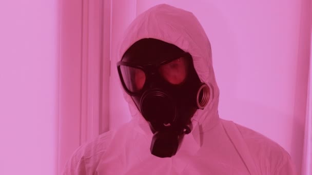 一个戴防毒面具的男人一个穿着白色工作服的化学防护人员 化学辐射污染 化学警报 环境污染 预防感染的安全服 — 图库视频影像