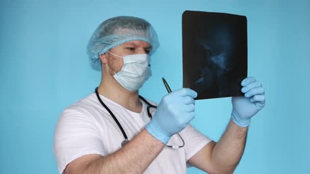 医生手里拿着脑部的X光照片一位穿着医用耳鼻喉科医生制服的医院医生检查鼻咽疾病 神经外科医生分析人类颅骨的创伤 — 图库视频影像