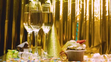 Doğum günü geçmişi pasta ve yanan mumlarla dolu. Mutlu yıllar altın arka plan, şenlikli şampanya kadehleri. Kopyalama alanının yıldönümü