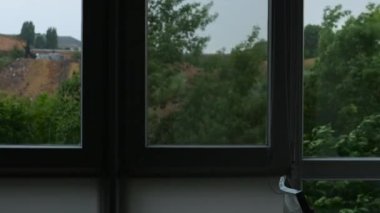 Pencerenin dışında şiddetli bir fırtına var. İklim değişiyor, pencerenin dışındaki bir kasırga rüzgarla ağaçları kırıyor. Güçlü rüzgar ağacı sallıyor. Fırtına. Pencerede sağanak yağmur