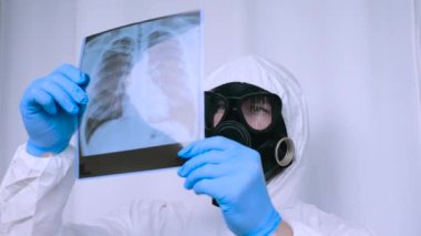 Gaz maskeli kimyasal koruyucu giysili bir adam röntgende turbeküloz hastası radyasyona karşı giysi giymiş bir adam. Laboratuvarda araştırma. Solunum yolu enfeksiyonu