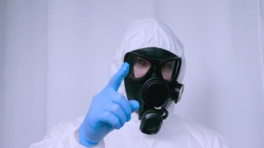 Kimyasal koruyucu giysili, gaz maskeli bir adam işaret parmağıyla birini işaret ediyor. Radyasyona karşı takım elbiseli bir adam. Kameraya vücut dilini parmağınla gösteriyorsun..