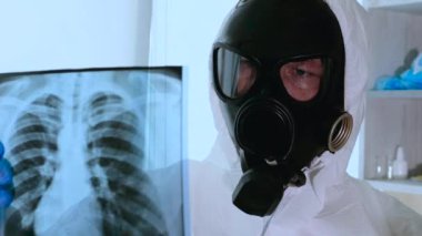 Laboratuvarda röntgende akciğerlere radyoaktif hasar. Gaz maskeli bir işçi radyasyon hasarını inceliyor. Kimya laboratuvarı. Türbeküloz analizi