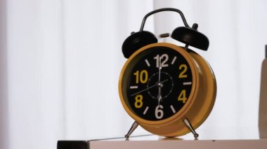 Bir adam sabah alarmını eliyle kapatır ve uyuyan adamı yatakta uyandırır. Kalkma zamanı, sabahın 6 'sında çalar saatin başında. Bir insanın sabah doğuşu. Çalar saat bir adamı uyandırdı.