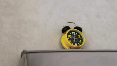 Alarmlı saat adamı yatakta uyandırır, sabah 7 'de çalar saat çalar, adam yatakta uyanır. Adam çalar saati kapatıyor..