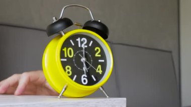 Alarmlı saat, yatakta uyuyan bir adamı uyandırır, sabahın altısında çalar saati çalar, bir adam yatakta uyanır. Adam alarmı kapatıyor..