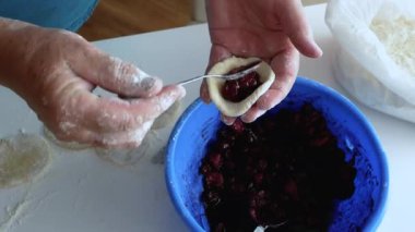 Kirazlı hamur köftesi yapan kadın, mutfakta buğday unundan yemek pişiren kadın, yaşam tarzı. Meyvelerden hamur köftesi heykeli yap. Ev yemeği konsepti