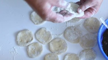 Kirazlı hamur köftesi yapan kadın, mutfakta buğday unundan yemek pişiren kadın, yaşam tarzı. Çilekli börek. Ev yemeği konsepti