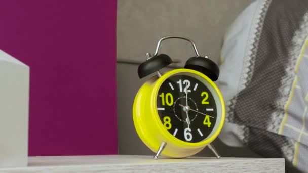 朝のレトロな警報時計が人のベッドの近くで鳴っている 目覚まし時計は朝起きてベッドで寝ている デスクトップ上のレトロアラーム時計リング — ストック動画