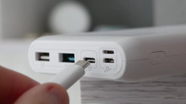 Hızlı şarj etme, USB tip C çıktılı akıllı telefon, bir kişi akıllı telefonu kabloyla şarj ediyor. USB bağlantısını şarj güç bankasına tak