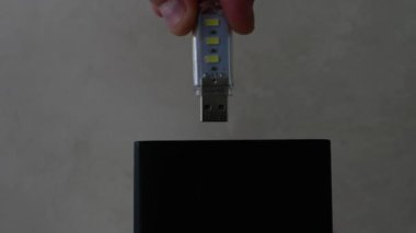  Ekonomik aydınlatma, şarj istasyonundaki lambanın parıltısı, kişi bataryaya USB ampulü yerleştiriyor. Oda ışıklandırması için enerji tasarrufu lambası