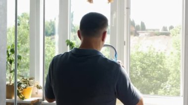 Yaşlı bir adam kulaklıkla müzik dinler, yaşlı bir adam kafasına müzik kulaklığı takar. Pencereden bakan adam müzik dinliyor.