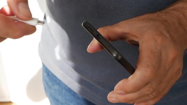 Seorang Pria Tua Mengenakan Biaya Smartphone Melalui Pengisian Daya Bank — Stok Video