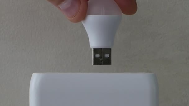 충전소에 램프의 사람은 건전지로 Usb 전구를 삽입합니다 클로즈업 조명을위한 에너지 — 비디오