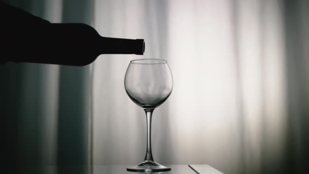 シルエット ボトルから赤ワインをガラスに注ぎ込み ゆっくりと動き 白いベロアカーテンの背景に対してガラスグラスに天然ワインを注ぎます アルコールドリンクグレープ — ストック動画